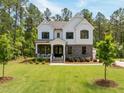 Beautiful two-story home with manicured lawn and a backdrop of lush green trees at 1338 The Parks Dr, Pittsboro, NC 27312