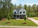 Expansive front lawn, with a basketball court and a backdrop of lush green trees at 1338 The Parks Dr, Pittsboro, NC 27312