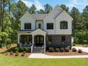 Beautifully landscaped two-story home featuring stone accents and a welcoming covered porch at 1338 The Parks Dr, Pittsboro, NC 27312