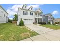 Attractive two-story home featuring a well-manicured lawn, two car garage, and charming front porch at 145 Cassada Ct, Holly Springs, NC 27540