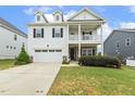 Beautiful two-story home with a two car garage, inviting porch, and lush green lawn at 145 Cassada Ct, Holly Springs, NC 27540