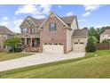 Charming brick home with a three car garage, well-kept lawn, and inviting curb appeal at 1704 Fawn Chase Ct, Wake Forest, NC 27587