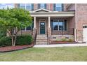 Inviting front porch with stone accents, wrought iron railing, and lush landscaping at 1704 Fawn Chase Ct, Wake Forest, NC 27587