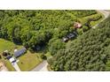 Aerial view of a charming home with a durable red metal roof surrounded by lush greenery at 1908 Rocky Cross Rd, Zebulon, NC 27597