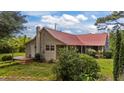 Charming home featuring a durable red metal roof, deck and well-maintained lawn at 1908 Rocky Cross Rd, Zebulon, NC 27597