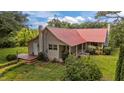 Charming home featuring a durable red metal roof, deck and well-maintained lawn at 1908 Rocky Cross Rd, Zebulon, NC 27597
