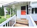 Close-up of the welcoming front porch with a white railing and bright orange door with house number at 2006 N Ashland Dr, Burlington, NC 27217
