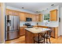 Bright kitchen with wood cabinets, stainless steel appliances, granite countertops, and a functional center island at 227 Kenmont Dr, Holly Springs, NC 27540