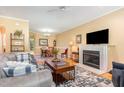 Inviting living room featuring a cozy fireplace, hardwood floors, and an open layout to the dining area at 227 Kenmont Dr, Holly Springs, NC 27540