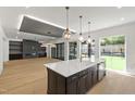 The open-concept kitchen features a center island with pendant lighting, custom cabinetry, and stainless appliances at 2805 Van Dyke Ave, Raleigh, NC 27607