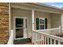 Cozy front porch with a secure glass door and white railing offers a private entrance at 320 Madres Ln, Morrisville, NC 27560