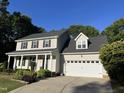 A lovely home featuring a two-car garage, pillared entry, and a landscaped front yard at 395 Wyndham Place Dr, Fuquay Varina, NC 27526