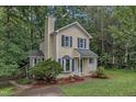 Beautiful two-story home with a lush green lawn and mature landscaping in wooded location at 4009 Olde Coach Rd, Durham, NC 27707