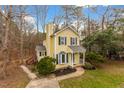 Inviting two-story home with yellow siding, dark shutters, bay window, and a well-kept front lawn at 4009 Olde Coach Rd, Durham, NC 27707