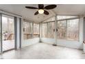 Bright sunroom with large windows offers scenic outdoor views and natural light, enhanced by a ceiling fan at 4009 Olde Coach Rd, Durham, NC 27707