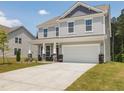 Charming two-story home with light gray siding, stone accents and a two-car garage at 516 Winding Creek Dr, Lillington, NC 27546
