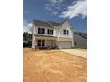 Charming two-story home with white siding, black shutters and a two car garage and long driveway at 516 Winding Creek Dr, Lillington, NC 27546
