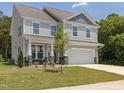 Charming two-story home with light gray siding, stone accents and a two-car garage at 516 Winding Creek Dr, Lillington, NC 27546