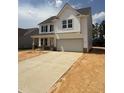 Charming two-story home with white siding, black shutters and a two car garage and long driveway at 516 Winding Creek Dr, Lillington, NC 27546