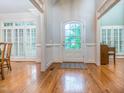 Bright foyer with hardwood floors, wainscoting, and a windowed front door allowing natural light at 5401 Fire Pink Way, Raleigh, NC 27613