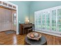 Sitting room showing a charming piano, shuttered windows, and view into foyer with beautiful hardwood floors at 5401 Fire Pink Way, Raleigh, NC 27613