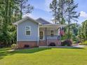 Close up of the front porch with brick base, railing and American flag at 707 Lakewood Dr, Siler City, NC 27344