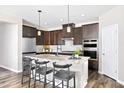 Modern kitchen with dark wood cabinets, granite countertops, stainless steel appliances, and center island at 904 Emmer St, Rolesville, NC 27571