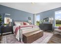 Stylish bedroom with large windows, a cozy bed, and elegant furnishings, perfect for relaxation at 904 Emmer St, Rolesville, NC 27571