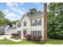 Attractive two-story house featuring black shutters and a brick chimney surrounded by lush trees at 104 Odessa Cir, Cary, NC 27513