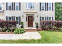 Inviting entrance with manicured landscaping, brick steps, and a charming front door with wreath at 104 Odessa Cir, Cary, NC 27513