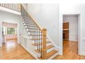 Elegant staircase with wood treads, white risers, and iron balusters providing a classic look at 104 Odessa Cir, Cary, NC 27513