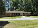 Classic brick home with tidy landscaping, set against a backdrop of mature trees and blue sky at 106 N Lakeside Dr, Smithfield, NC 27577