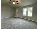 Spacious living room with neutral walls, carpet flooring, and a ceiling fan, creating a serene atmosphere at 110 Coharie Dr, Lillington, NC 27546