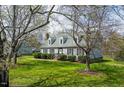 A charming two-story home with a well-manicured lawn framed by mature trees, creating a picturesque setting at 110 W Quail Ridge Rd, Oxford, NC 27565