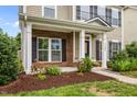 Close-up of a cozy front porch with brick accents, elegant columns, and attractive landscaping at 1144 Survada Ln, Morrisville, NC 27560