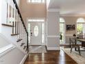 Bright foyer with hardwood floors, staircase, arched windows, and a decorative front door, offering a grand entrance at 121 Flint Point Ln, Holly Springs, NC 27540