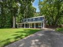 Stately home surrounded by lush greenery features a welcoming front porch and manicured lawn for a picturesque setting at 1215 Brookgreen Dr, Cary, NC 27511