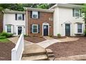 Charming townhome exteriors featuring brick and white siding with manicured landscaping at 129 Assembly Ct, Cary, NC 27511
