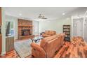Comfortable living room with a brick fireplace, hardwood floors, and light green walls at 1413 Roy Averette Dr, Raleigh, NC 27603