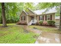 Attractive home showcasing lush greenery, colorful flowers, and a inviting walkway to the front door at 1510 Bungalow Ave, Durham, NC 27703