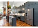 Modern kitchen with stainless steel appliances, gray cabinetry, and a central island at 1535 Caraleigh Mills Ct # 111, Raleigh, NC 27603