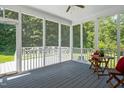 Inviting screened porch with wooden floors and serene views of the surrounding greenery at 1605 Baneberry Ct, Willow Springs, NC 27592