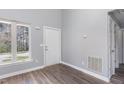 Entryway with wood-look floors, bright window, and a white six-panel front door at 1809 Coltrane Ct, Raleigh, NC 27610