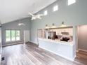 Open-concept living room with modern flooring, vaulted ceilings, and a combined kitchen area at 1809 Coltrane Ct, Raleigh, NC 27610