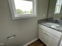 Bathroom with granite countertops, white vanity, modern fixtures and a large window at 186 Coharie Dr, Lillington, NC 27546