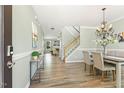 Elegant dining room with hardwood floors, chandelier, and staircase in a well-lit interior at 2128 Feather Ridge Dr, Holly Springs, NC 27540