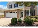 Attractive two-story home with brick accents, a two-car garage, and neat landscaping at 2128 Feather Ridge Dr, Holly Springs, NC 27540