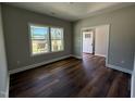 Bright bedroom featuring stylish wood floors and ample natural light from large windows at 217 Busterfield Ct, Benson, NC 27504
