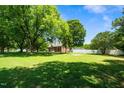 Expansive green lawn surrounded by mature trees, creating a serene and private atmosphere for the home at 2417 Ridgeford Ct, Fuquay Varina, NC 27526