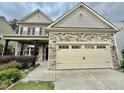 Charming two-story home with stone accents and a beige garage door under a cloudy sky at 2511 Kestrel Heights Ct Ct, Durham, NC 27703